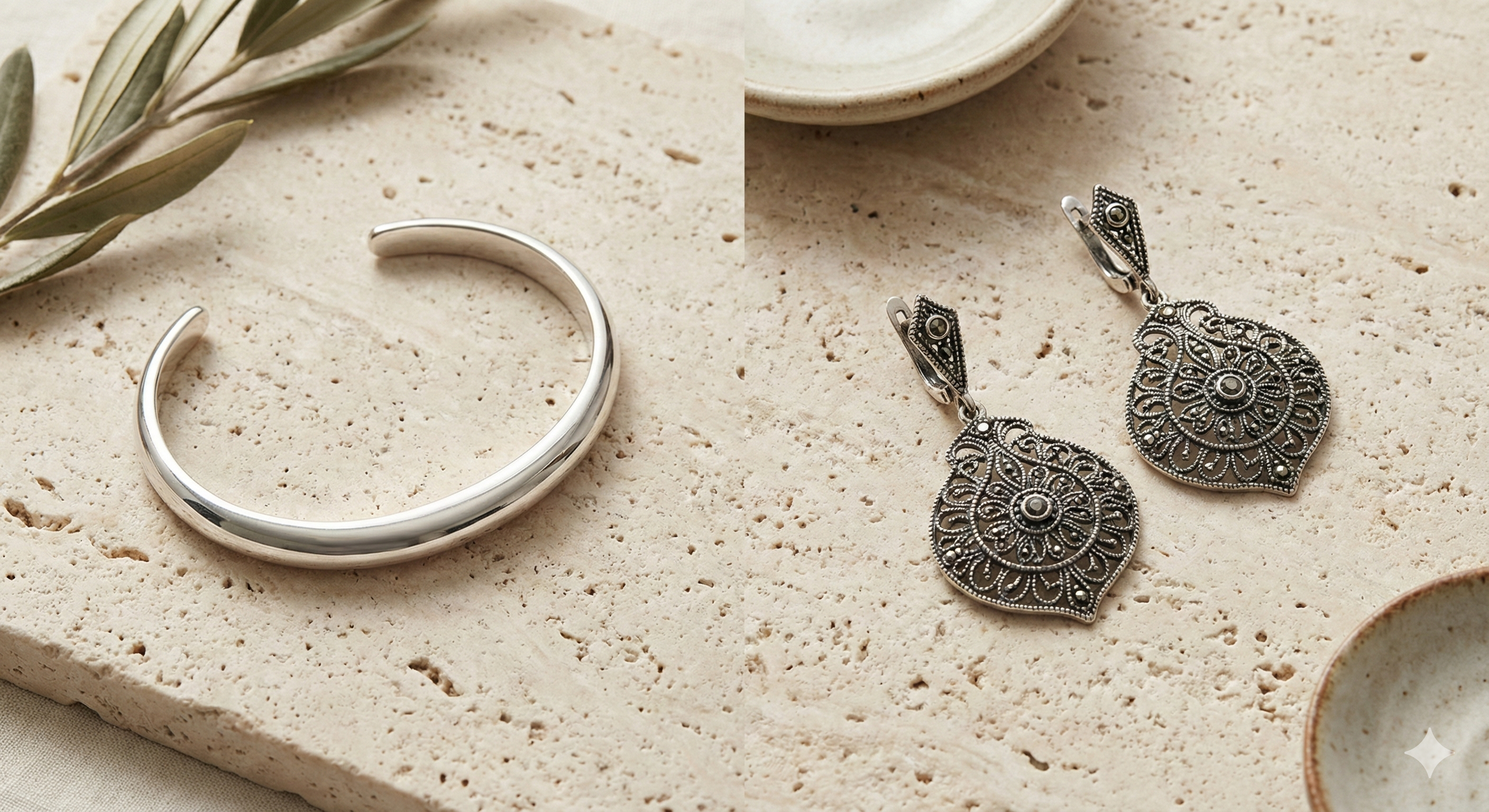 Artistic flatlay of silver jewelry on stone surface